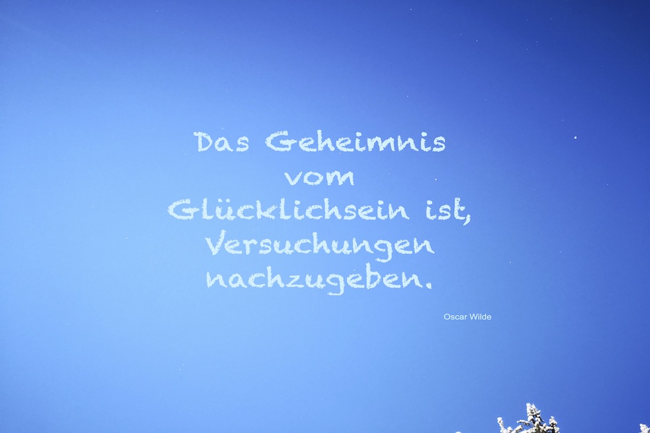 blauer Himmel, im rechten unteren Eck ein verschneiter Baumwipfel. Ein Spruch von Oscar Wilde in hellblau.